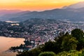 Aerial view of the lake Lugano surrounded by mountains and evening city Lugano on during dramatic sunset, Switzerland, Alps. Royalty Free Stock Photo