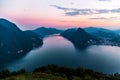 Aerial view of the lake Lugano surrounded by mountains and evening city Lugano on during dramatic sunset, Switzerland, Alps. Royalty Free Stock Photo