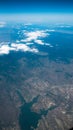 Aerial view of lake and mountains. View from a plane window. Beautiful landscape under the clouds and blue sky Royalty Free Stock Photo