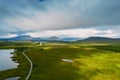 Aerial view on a lake and a small road to a mountains. Vast empty green fields. Connemara, county Galway, Ireland. Travel and