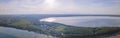 Aerial view of lake and small village on the peninsula. Sunset evening light by calm water on warm beautiful summer day. Royalty Free Stock Photo