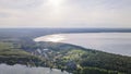 Aerial view of lake and small village on the peninsula. Sunset evening light by calm water on warm beautiful summer day. Royalty Free Stock Photo