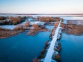 Aerial view of lake and snow covered bridge over it during nice sunrise in Lithuania - Winter landscape Royalty Free Stock Photo