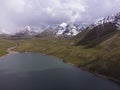 Aerial view of lake surrounded by snow capped peaks in the Tian Shan Mountains of Kyrgyzstan Royalty Free Stock Photo