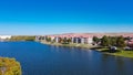 Aerial view lakeside apartment building near business warehouse and landfill trash hill in background