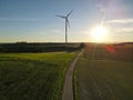 Aerial view of a landscape with agriculture fields, a road and a wind turbine on a sunny evening in summer