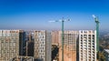 Aerial view of landscape in the city with under construction buildings and industrial cranes. Construction site. Royalty Free Stock Photo