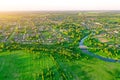 Aerial view landscape of winding small river among the small town, stream in green field meadow, top view Royalty Free Stock Photo