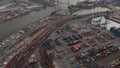 Aerial view of large cargo container terminal in Hamburg with reveal of the river and city industrial district