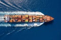 Aerial view of a large container ship in motion over blue, open ocean