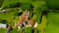 Aerial view of large English county house surrounded by lush greenery