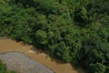 Aerial view of a large and fast flowing tropical river with muddy brown water alongside a tropical rainforest Royalty Free Stock Photo