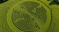An aerial view of a large, intricately designed crop circle in a grassy field. The pattern is Royalty Free Stock Photo