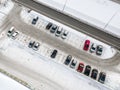 Aerial view of a large number of cars of different brands and colors standing in a parking covered with snow lot near the shopping Royalty Free Stock Photo