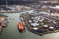 Aerial view of a large orange oil tanker moored at an oil storage silo terminal in an industrial port Royalty Free Stock Photo