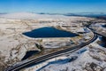 Aerial view of a large reservoir next to a major dual carriageway on a snowy day Royalty Free Stock Photo