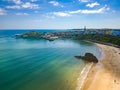 Aerial view of a large sandy beach and colorful buildings behind (Tenby, Wales