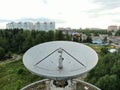 Aerial view is a large space antenna against a green forest. Space communications