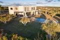 Aerial view of a large white contemporary house in geometric shapes with an uncluttered land around