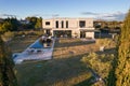 Aerial view of a large white contemporary house in geometric shapes with an uncluttered land around