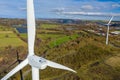 Aerial View of 2 large wind turbine stationary on beautiful welsh landscape. clean energy concept. close up shot Royalty Free Stock Photo