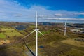 Aerial View of 2 large wind turbine stationary on beautiful welsh landscape. clean energy concept. close up shot Royalty Free Stock Photo