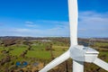Aerial View of large wind turbine stationary on beautiful welsh landscape. clean energy concept. close up shot of blades Royalty Free Stock Photo