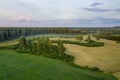 Aerial view of Latvian rural landscape with agricultural fields, forests and roads at sunset