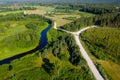 Aerial view of Latvian rural landscape with a winding river, forests and country roads at sunset