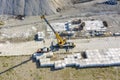 Aerial view of the lifting big concrete blocks for harbor construction by a large crane. Royalty Free Stock Photo