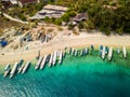 Aerial view of lines of wooden tourist boats on a sandy beach of a tropical island Royalty Free Stock Photo