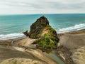Aerial view of the Lion Rock on Piha Beach with a cloudy sky in the background, New Zealand Royalty Free Stock Photo