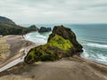 Aerial view of the Lion Rock on Piha Beach with a cloudy sky in the background, New Zealand Royalty Free Stock Photo