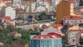 Aerial view of Lisbon skyline with road and aqueduct. Historic buildings near Campo de Ourique district with green trees