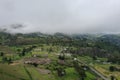 Aerial view of a little village covered in fog and surrounded by farmland at a high altitude in de andean mountains of Ecuador Royalty Free Stock Photo