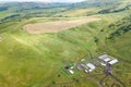 Aerial view of livestock plots and agricultural green fields in nature in the Altai Mountains with small houses of farm, tractors Royalty Free Stock Photo