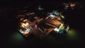 Aerial view of loading from fishing ships to cargo trucks in harbor port at night