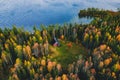 Aerial view of log cabin in autumn colors forest by blue lake in rural fall Royalty Free Stock Photo