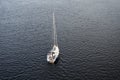 Aerial view of lone white sailboat with removed sails at sea Royalty Free Stock Photo