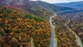 Aerial view of long asphalt road on the hill surrounded by colorful autumn forests in Macedonia Royalty Free Stock Photo