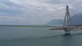 Aerial view of long cable-stayed Rio bridge in Greece at clouds weather, Ferry station