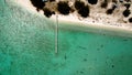 Aerial view on a long pier at the island`s white sand beach with turquoise waters around.