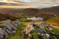 Aerial view of Loughrigg Tarn with rocks in foreground on a beautiful Autumn morning. Lake District, UK. Royalty Free Stock Photo