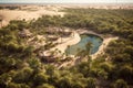 aerial view of a lush oasis surrounded by sand dunes