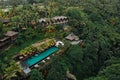 Aerial view of luxury hotel with straw roof villas and pools in tropical jungle and palm trees. Luxurious villa, pavilion in Royalty Free Stock Photo