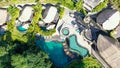 Aerial view of luxury hotel with villas and pool in tropical jungle and palm trees. Luxurious villa, pavilion in forest