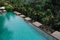 Aerial view of luxury infinity pool in tropical jungle and palm trees. Luxurious villa, swimming pool in forest, Ubud, Bali Royalty Free Stock Photo