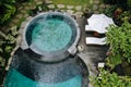 Aerial view of luxury round pool with white umbrellas and sun beds in tropical jungle and palm trees. Luxurious villa, swimming