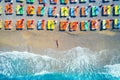 Aerial view of lying woman on the beach with colorful chaise-lounges. Beautiful young woman on the sea at sunset in Oludeniz