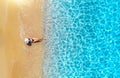 Aerial view of a lying woman in hat on sandy beach and blue sea Royalty Free Stock Photo